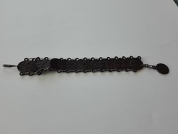 Pénzérmékhez hasonló korongokból álló fém karkötő