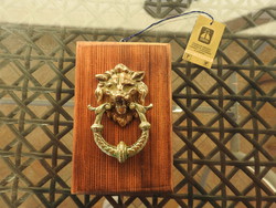Polish copper lion head ornament knocker on a wooden base - with label