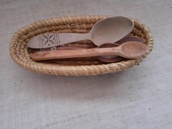 An old handmade mat basket with a carved wooden spoon