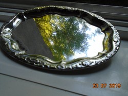 Chromed metal tray with an oval convex rim pattern
