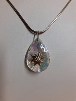 Polished glitter crystal pendant in the middle adorned with alpine weeds on a long special chain