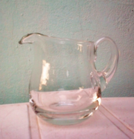 Older glass belly pitcher pouring vinegar lemon juice cream