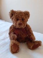 Brown teddy bear with satin ribbon around his neck