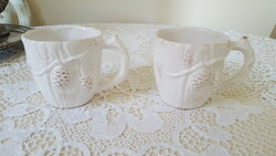 2 ceramic mugs decorated with pine wood and cones.