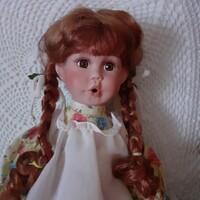 Sitting porcelain doll with a surprised face
