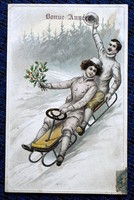 Antique New Year greeting litho postcard cheerful lady and gentleman on a bobsleigh in a winter landscape with holly