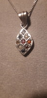 Old minimal silver pendant encrusted with precious stones on a silver chain