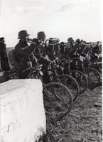 Kerékpáros katonák jelző kürtöt fújnak, virágcsokrokkal