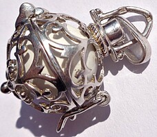 White ball jingling in a silver openwork sphere, silver pendant