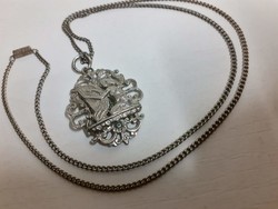 Openwork pattern pendant depicting a retro harpist woman on a chain