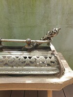 Decorative antique fireplace insert with accessory shovel, sophisticated metal work, elegant decorative wrought iron