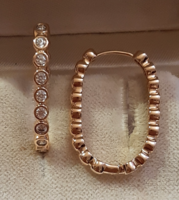 Oval hoop earrings with zircons on a gold-plated buton