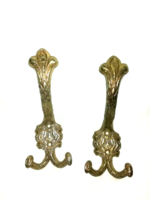 A pair of decorative gold-colored metal hangers