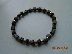 Szabálytalan fekete ásvány és Swarovski fazettált arany színű gyöngyökből,karkötő