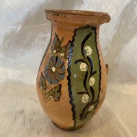 A folk ceramic mug with a flower pattern