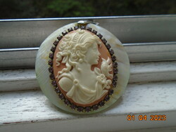 Cameo pendant on a mother-of-pearl base, glazed with polished small purple claw stones, marked 18 kgp