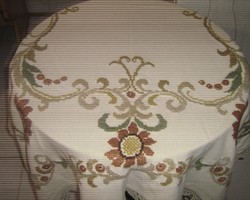 A special woven tablecloth with a crocheted edge with a beautiful, richly hand-embroidered baroque flower pattern