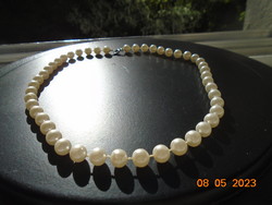 Older necklace made of individually knotted white pearls with silver-plated clasp