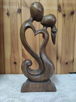 Kiss. Hugging loving couple forming a common heart. Carved wooden statue. Feng shui ornament..