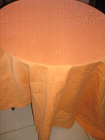A beautiful oval damask tablecloth with a peach-yellow leaf pattern