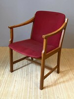 Elegant women's armchair with a red cover next to a desk in condition to be renovated