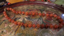 40 cm-es , meleg-borostyános színű , karneol gyöngyökből álló nyaklánc .