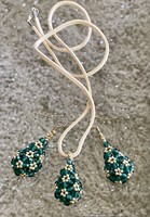 Sötétzöld színű csepp alakú csiszolt gyöngyökből készült fülbevaló medál hasított bőr szálon