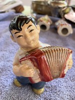 Porcelain boy figure with a Chinese accordion