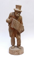 A carved wooden sculpture with an accordion