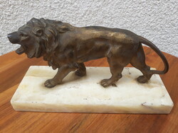 Antique bronzed metal lion statue on a marble base