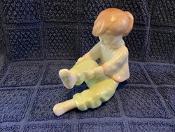 Aquincum porcelain figure of a little girl dressing up
