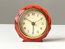 An unmarked retro clock alarm clock made by mom in red color with a plastic edge