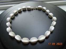 Old necklaces made of larger white rectangular beads with concave sides and a copper clasp