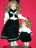 Antique beautiful porcelain doll brother and sister the sister and the little sister on a wooden surface the bigger one is 45 cm the smaller one is 23 cm