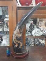 Large carved horn with a bird pattern on a wooden plinth. 42 Cm.