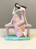 Plaster statue of a black-haired girl sitting on a bench 28 cm