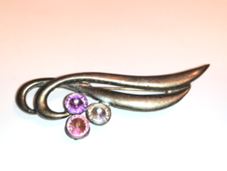 Silver colored brooch with white, pink and purple rhinestones. (452)