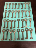 32 old cabinet keys. Length: 6 cm and holes inside. In good condition.