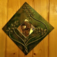 Decorative small mirror, decorated with copper tendrils, on a painted wooden sheet / 