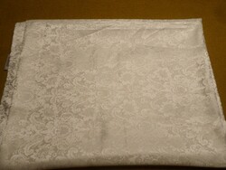 A large white tablecloth with a beautiful, elegant pattern.