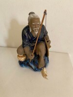Small ceramic figure of a sitting fisherman