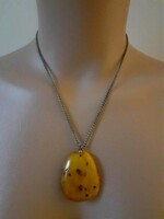 An old, possibly alpaca necklace with a larger amber pendant