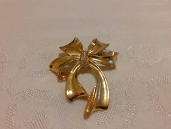 Gold-colored, bow-shaped brooch in good condition