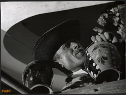 Nagyobb méret, Szendrő István fotóművészeti alkotása. Férfi kalapban, pipával, díszes vázák