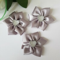 Silver-colored satin flower with a heart-shaped, shiny decoration