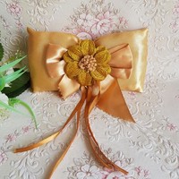 New, custom-made gold-colored wedding ring pillow with sparkling flower clasp
