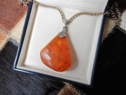 Old silver pendant with amber on a gold-plated chain