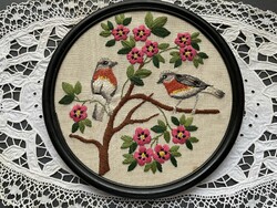 Beautiful thread embroidery round image with robins on a blooming tree branch