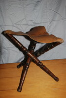 Old three-legged folding hunting chair, leather anvil