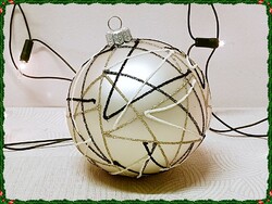 Large, beige-colored glass sphere Christmas tree decoration with a bulging abstract pattern.